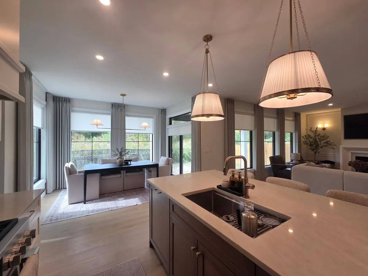 Kitchen and dining room with pleated drapery and roller shades